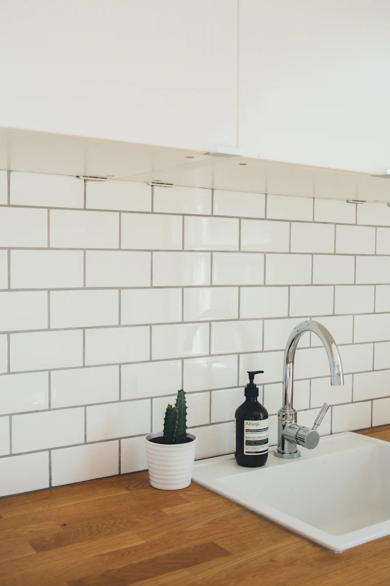 White subway tile backsplash behind a kitchen faucet