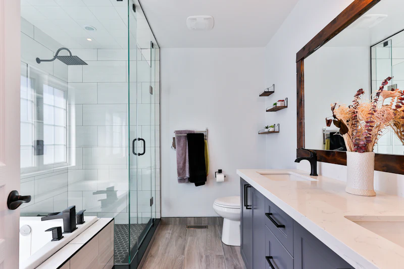 Remodeled bathroom with a glass shower and a dark vanity